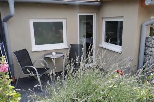 a patio with chairs and a table and windows at Arthouse Apartment 2 in Bad Vilbel
