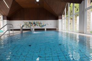 a swimming pool with a fountain in a building at BSW-Erlebnishotel Festenburg in Clausthal-Zellerfeld
