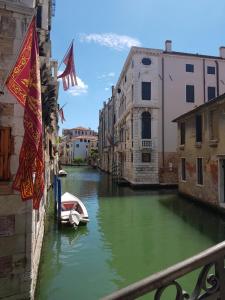 un petit bateau dans un canal d'une ville dans l'établissement Calle Rielo great canal view, à Venise