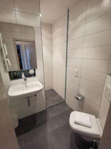 a white bathroom with a sink and a toilet at Bio-Weingut, Gästehaus und Kräuterhof in Flomborn
