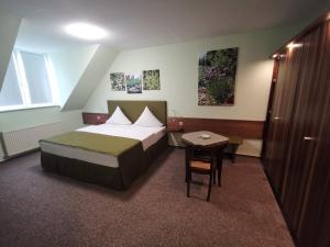 a hotel room with a bed and a table at Bio-Weingut, Gästehaus und Kräuterhof in Flomborn