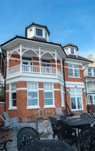 un edificio de ladrillo con mesas y sillas delante de él en Bay Tree Broadstairs en Broadstairs