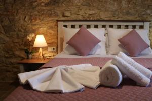 un letto con asciugamani e cuscini sopra di Vasilis House a Theológos