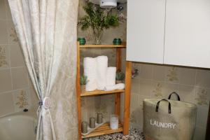 a bathroom with a shelf with towels and a tub at Vasilis House in Theológos +15 photos