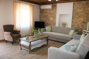 a living room with a couch and chairs and a table at Vasilis House in Theológos