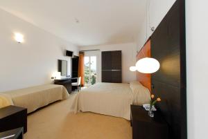 a hotel room with two beds and a television at Cerri Hotel in Castellammare del Golfo