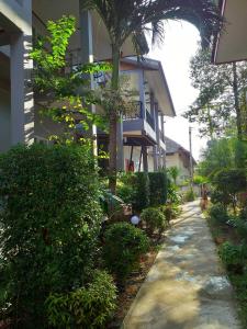 une maison avec des buissons et un trottoir devant elle dans l'établissement Tamarind Twin Resort, à Ko Lanta