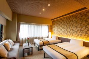 ein Hotelzimmer mit 2 Betten und einem Sofa in der Unterkunft HAUZA Kyoto Gojo Karasuma in Kyoto