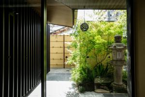 a garden with a stone fountain in the middle of a doorway at Hauza Kyoto Gojo Karasuma in Kyoto