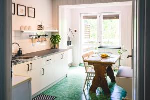 a kitchen with white cabinets and a wooden table at Czas na Puszczę in Puszcza Mariańska