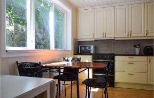 a kitchen with a table and chairs and a window at Beautiful Apartment In Mandal With Kitchen in Mandal