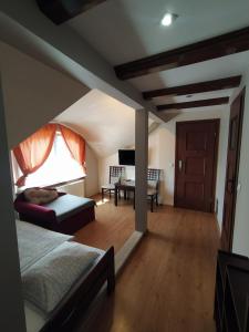 a bedroom with a bed and a living room with a piano at Camelot in Łeba