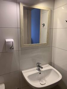 ein Bad mit einem Waschbecken und einem Spiegel in der Unterkunft Vouros Palace in Masouri