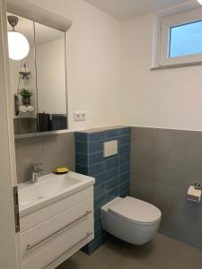 uma casa de banho com um WC, um lavatório e um espelho. em Schicht am Bach em Essen
