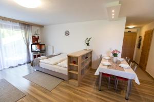a bedroom with a bed and a table and a dining room at Apartment Natur in Bled
