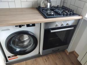a stove top oven next to a washing machine at Potal in Kremenchuk