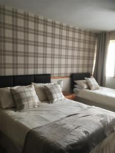 a bedroom with two beds with pillows on it at Lewinsdale Lodge in Weston-super-Mare