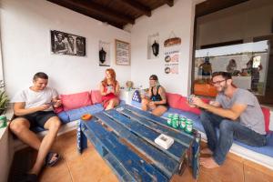 a group of people sitting on a couch at La Tortuga Hostel in Adeje