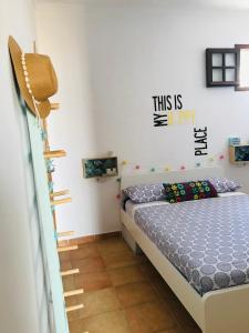 a bedroom with a bed with a sign on the wall at Preciosa casa baja con aire acondicionado in Sanlúcar de Barrameda