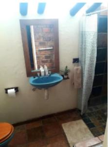 a bathroom with a blue sink and a mirror at The Lapa Apartment in Gobabis