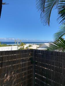 una valla con el océano al fondo en Bungalows Les Charmilles, en La Saline-Les-Bains