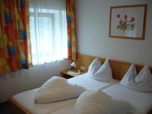ein Hotelzimmer mit 2 Betten und einem Fenster in der Unterkunft Gästehaus Post in Prägraten