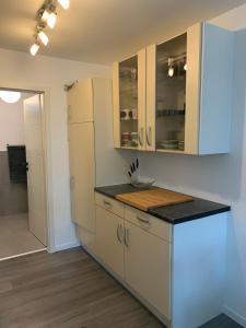 uma cozinha com armários brancos e um balcão preto em Schicht am Bach em Essen