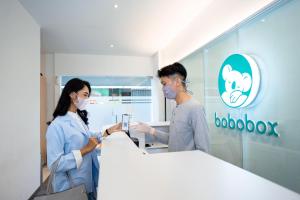 two people in a hospital room looking at a phone at Bobopod Pancoran, Jakarta in Jakarta