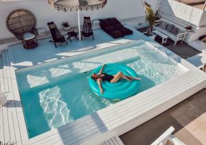 a woman floating on a raft in a swimming pool at Playa del Mar - Adults Only in Monopoli