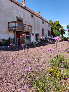 un bâtiment avec des fleurs roses devant lui dans l'établissement Domaine de cyrcé, à La Celle