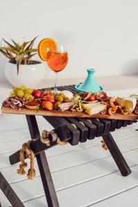 a tray of fruit and a drink on a table at Playa del Mar - Adults Only in Monopoli