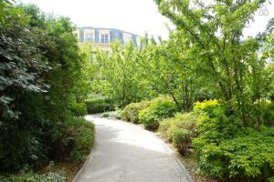 einen Weg durch einen Garten mit Bäumen und Sträuchern in der Unterkunft Apartment in Chessy very near Disneyland in Chessy