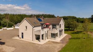 a large white house sitting on top of a field at Coolcormack Stud B&B in Waterford