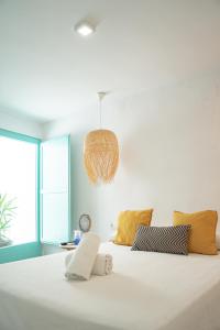 1 dormitorio con 1 cama blanca grande con almohadas amarillas en Respirar, en Peñíscola