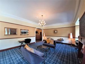 een hotellobby met banken en stoelen en een kroonluchter bij Buttermere Court Hotel in Buttermere