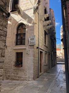 a stone building with a sign on it on a street at Apartment Teatar in Korčula