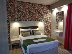 a bedroom with a large bed and a floral wall at Apartment Toula in Petra