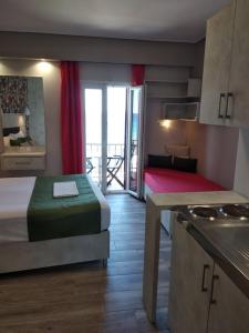 a bedroom with a bed and a kitchen with a balcony at Apartment Toula in Petra