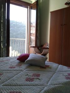 Schlafzimmer mit einem Bett und Blick auf einen Balkon in der Unterkunft B&B MonteMare in Tortora