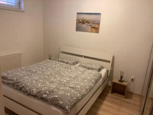 a bedroom with a bed and a painting on the wall at Patrik Apartment Šamorín in Šamorín