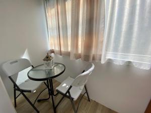 a table and two chairs in a room with a window at Home away - Chic and Cozy Apartment in Constanţa