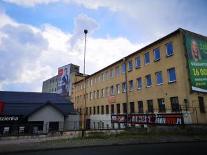 un gran edificio con letreros en el costado en Hostel Anilux, en Jelenia Góra