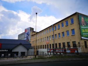 a large building with signs on the side of it at Hostel Anilux in Jelenia Góra