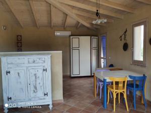 a room with a table and chairs and a kitchen at Appartamento a Feraxi in Muravera