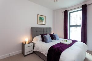 a bedroom with a large bed and a window at Self-contained town centre one bedroom apartments by Helmswood Serviced Apartments in Redhill