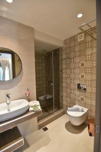 a bathroom with a sink and a toilet and a shower at On Board Luxury Studios in Sarti