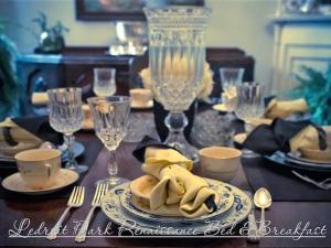 un tavolo da pranzo con un tavolo apparecchiato con piatti e posate di Ledroit Park Renaissance Bed and Breakfast a Washington