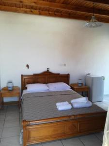 a bedroom with a bed with two towels on it at Oasis Hotel Loutro in Loutro