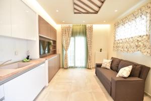 a living room with a couch and a kitchen at On Board Luxury Studios in Sarti
