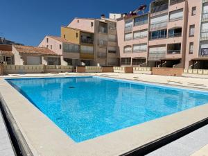 une grande piscine en face d'un bâtiment dans l'établissement richelieu 4 CAP AGDE, au Cap d'Agde